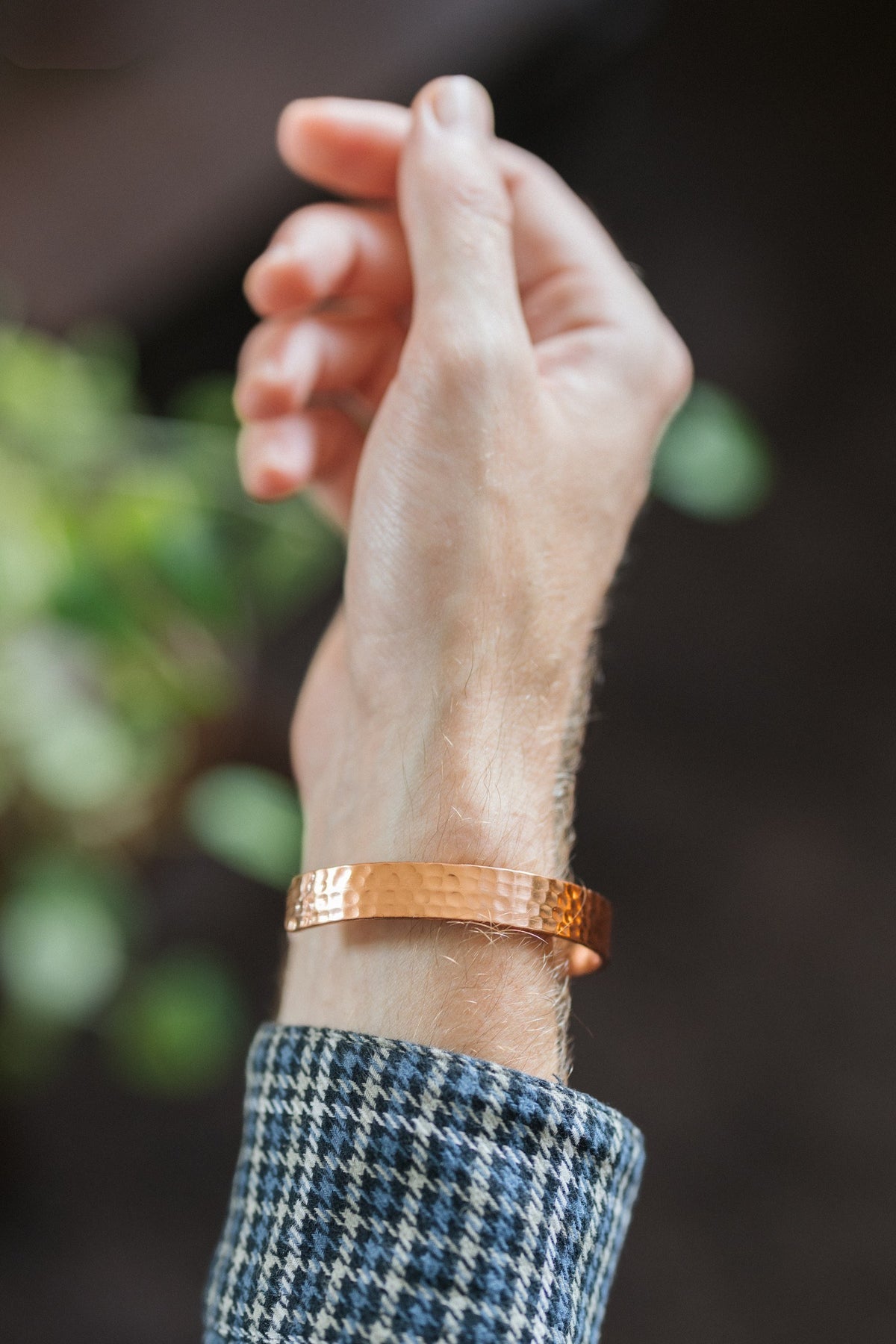 Kopero Kupferarmband Gehämmert, am Handgelenk, mit der Hand nach oben vor einem dunklen Hintergrund