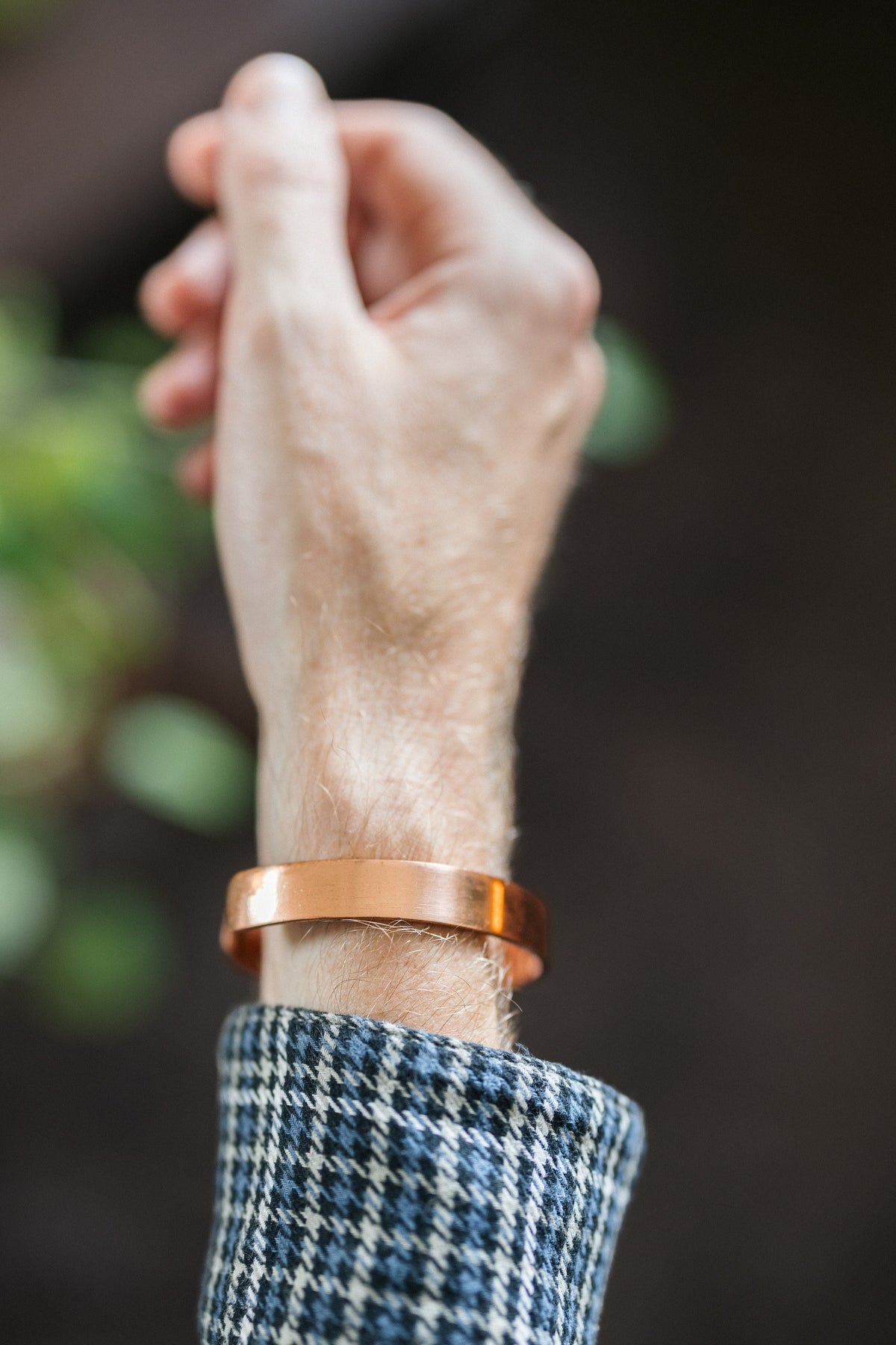 Kopero Kupferarmband Glatt, am Handgelenk, mit der Hand nach oben vor einem dunklen Hintergrund