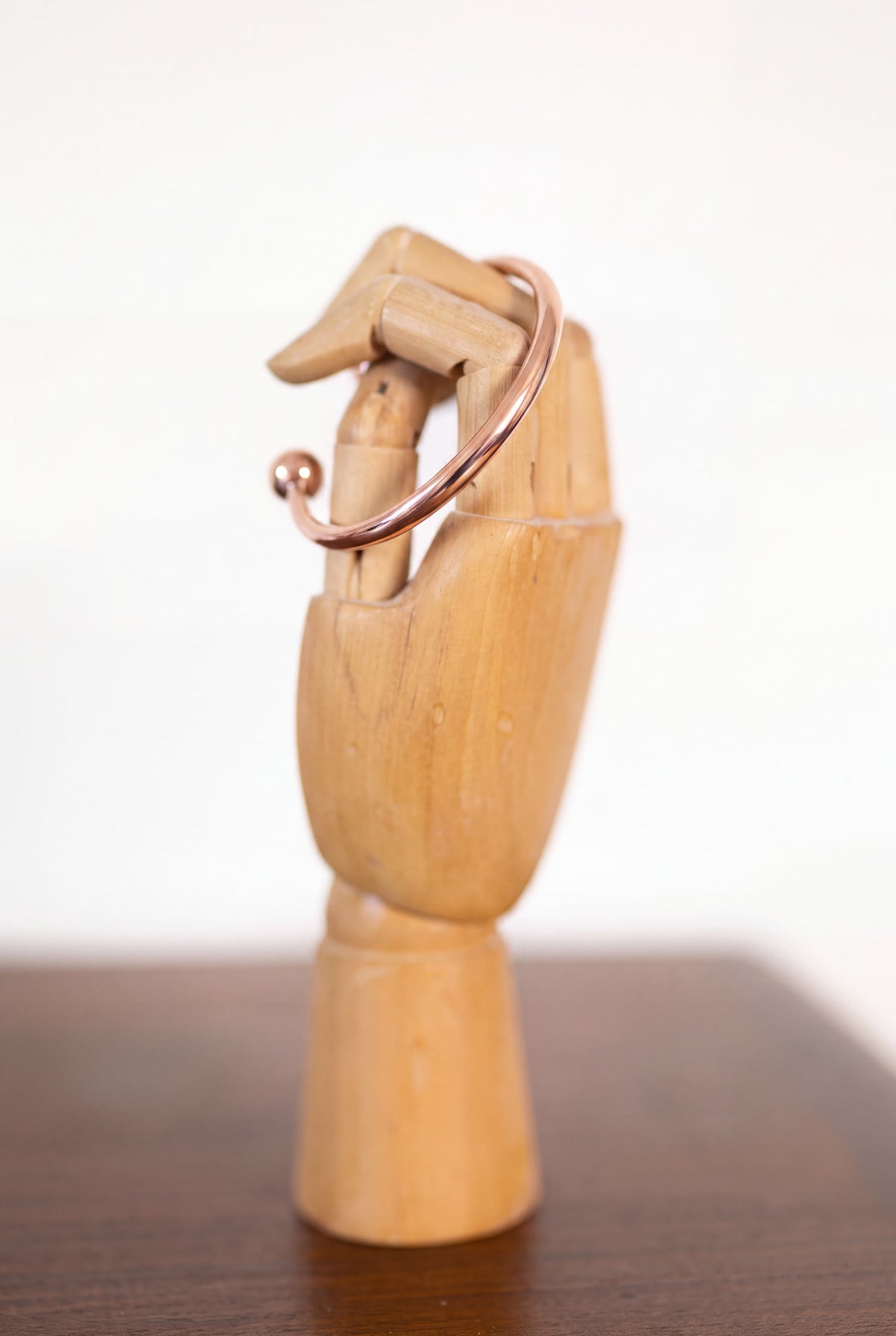 Kopero Kupferarmband Rund auf einer hölzernen Schmuckhand