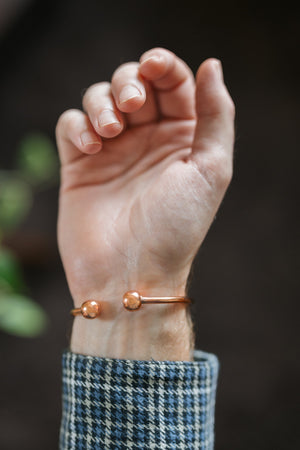 Kopero Kupferarmband Rund, am Handgelenk, mit den zwei Kügelchen an den Enden sichtbar