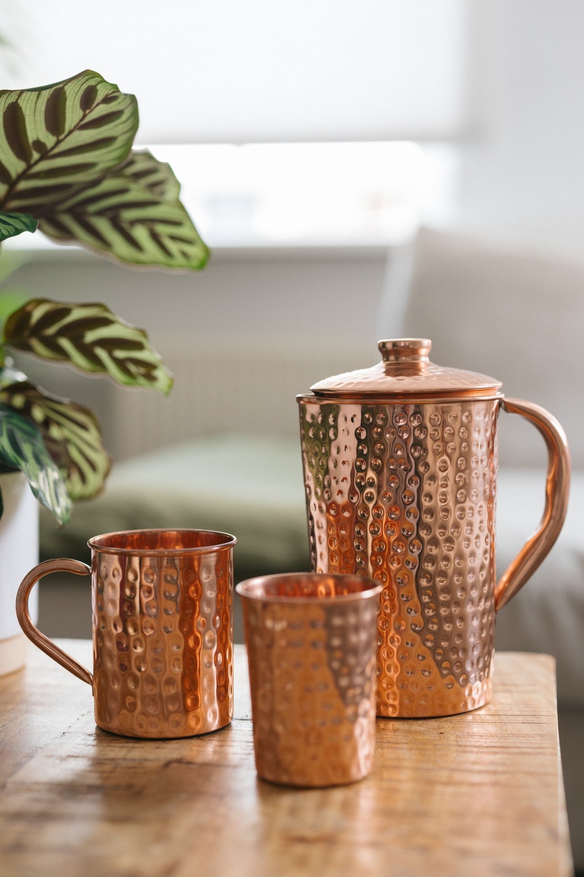 Kopero Kupferkanne Gehämmert, mit einer Tasse und einem Becher auf einem Holztisch
