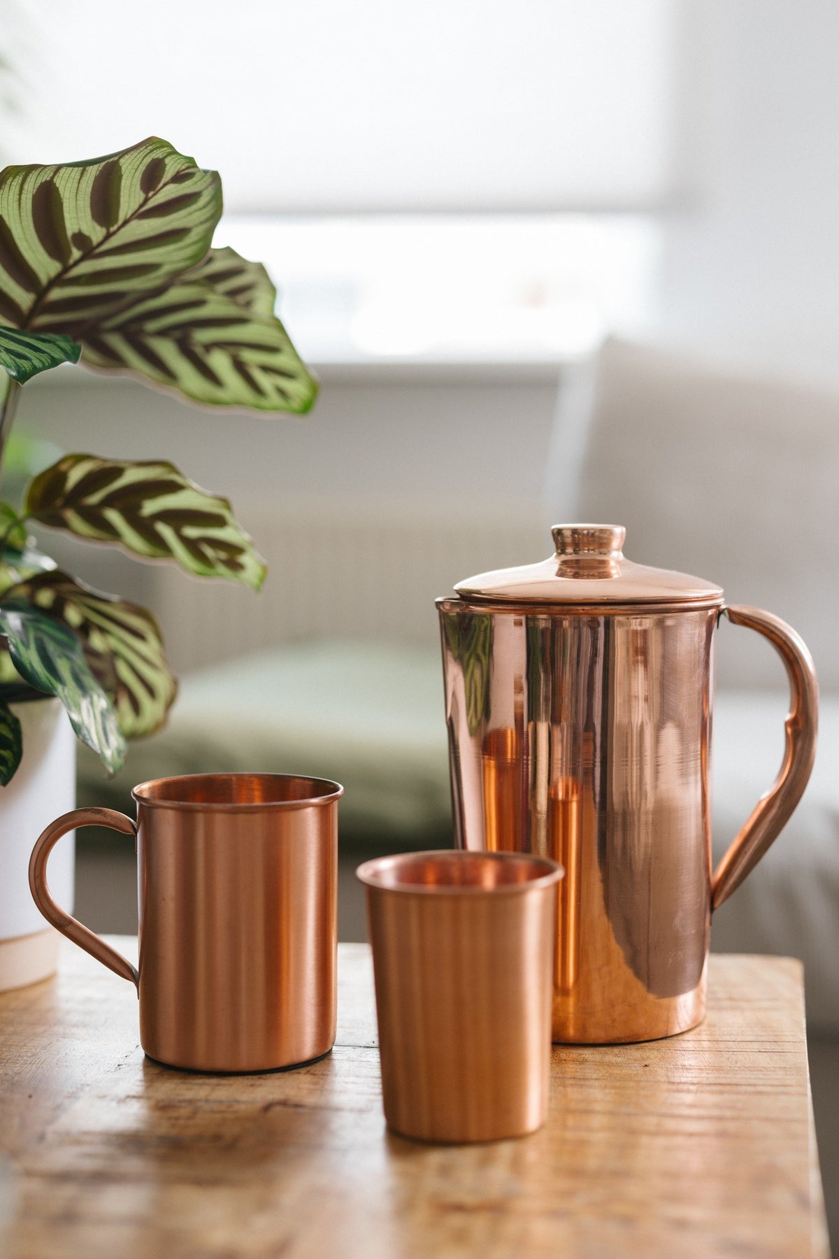 Kopero Kupferkanne Glatt, mit einer Tasse und einem Becher auf einem Holztisch
