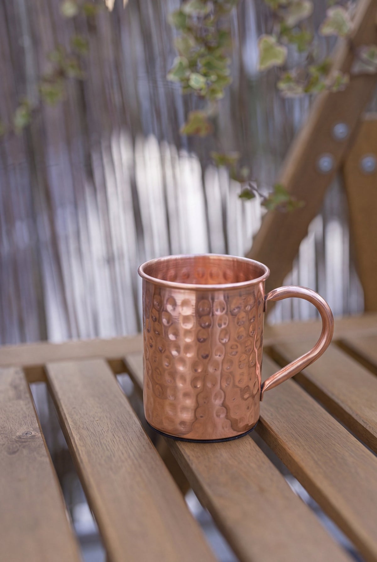 Kopero Kupfertasse Gehämmert, 400 ml, auf einer Holzgartenbank