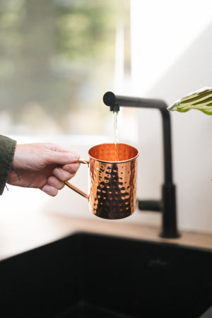 Kopero Kupfertasse Gehämmert, in einer Hand unter dem Wasserhahn
