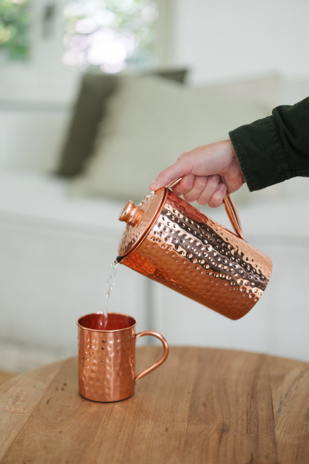 Kopero Kupfertasse Gehämmert, während Wasser aus einer kupfernen Kanne hineingegossen wird