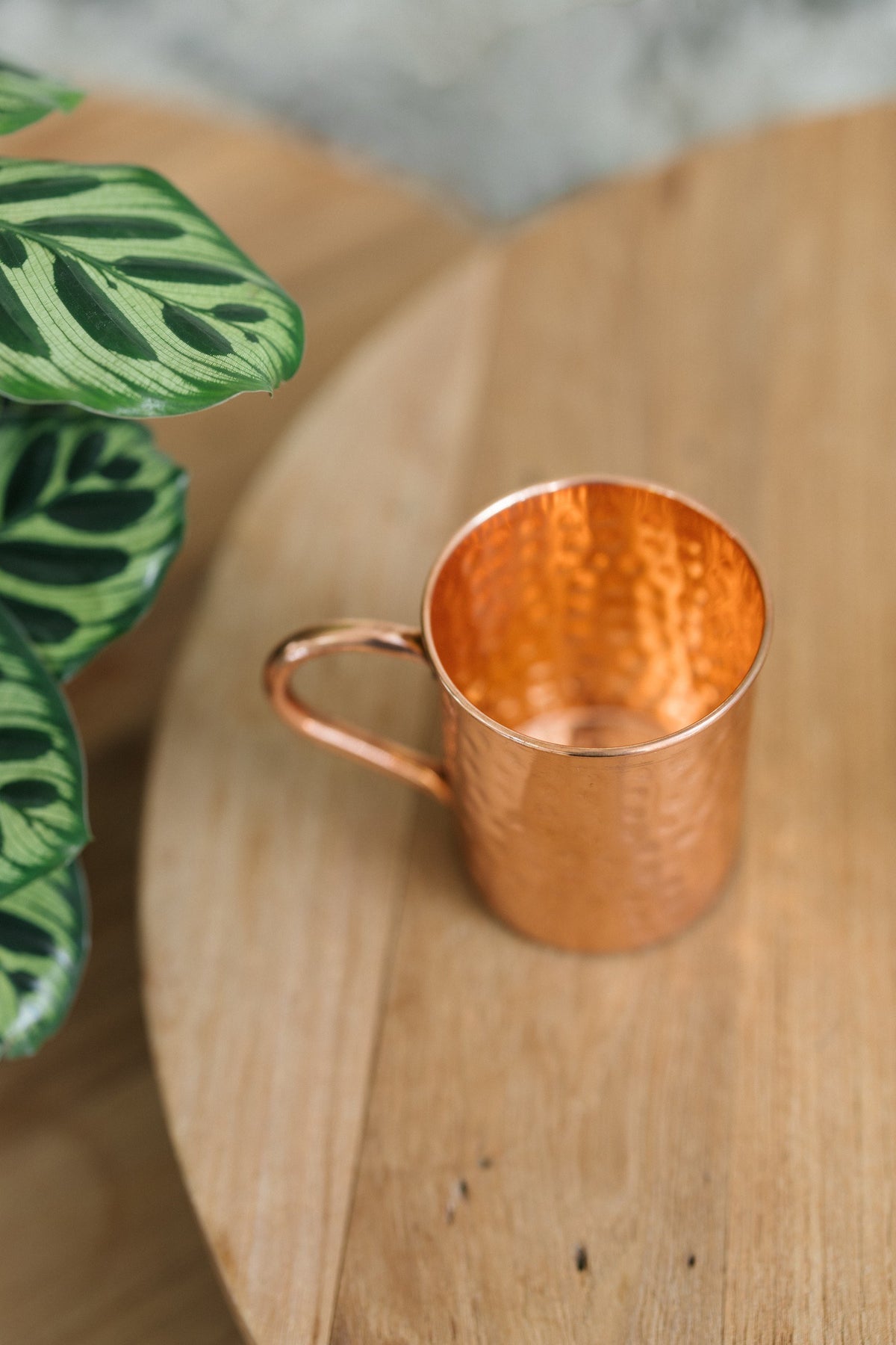 Kopero Kupfertasse Gehämmert, auf der Seite liegend auf einem runden Holztisch