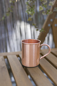 Kopero Kupfertasse Glatt, 400 ml, auf einer Holzgartenbank