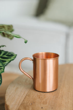 Kopero Kupfertasse Glatt, auf einem runden Holztisch vor einem Sofa