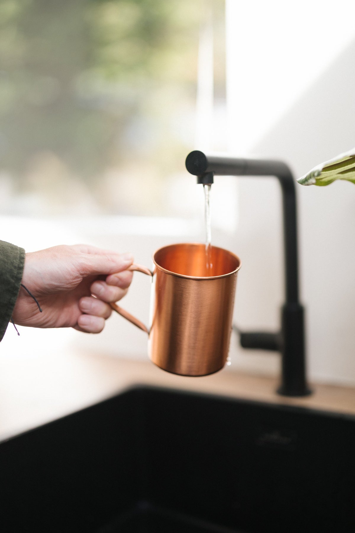 Kopero Kupfertasse Glatt, in einer Hand unter dem Wasserhahn