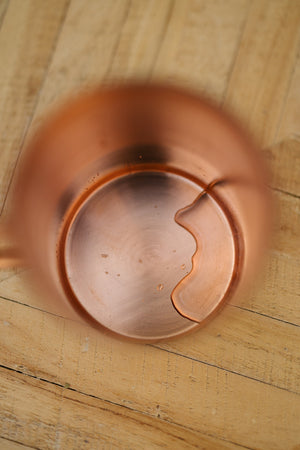 Kopero Kupfertasse Glatt, von oben gesehen: die Innenseite der Tasse auf einem Holztisch