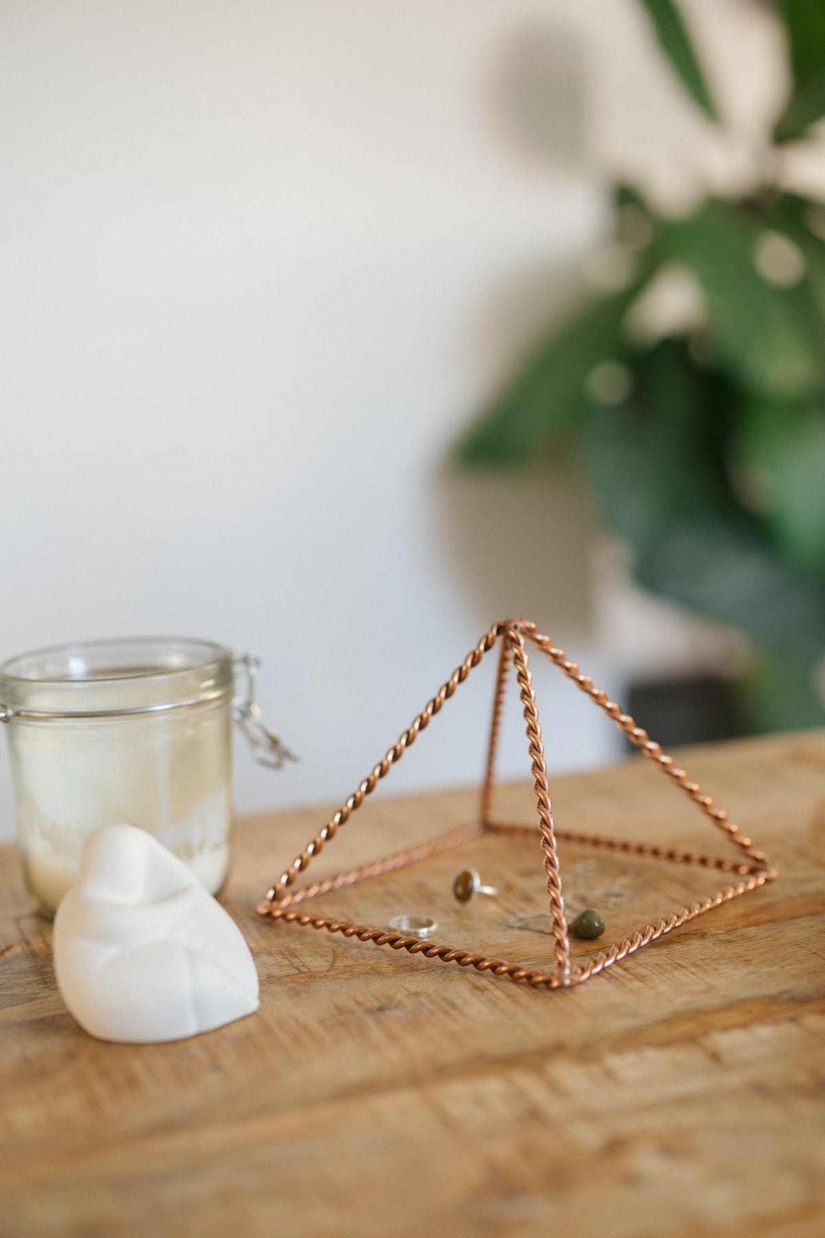 Kopero Kupfer-Pyramide Energizer Gedreht Klein (14,56 cm), mit Schmuck darunter neben einem Kerzenglas und einer Figur