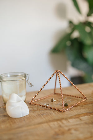Kopero Kupfer-Pyramide Energizer Gedreht Klein (14,56 cm), mit Schmuck darunter neben einem Kerzenglas und einer Figur