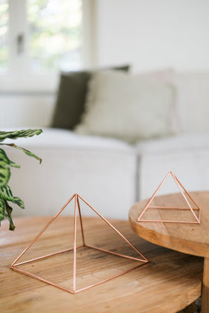 Kopero Kupfer-Pyramide Energizer Glatt, die kleine und die große Pyramide nebeneinander auf zwei Holztischen