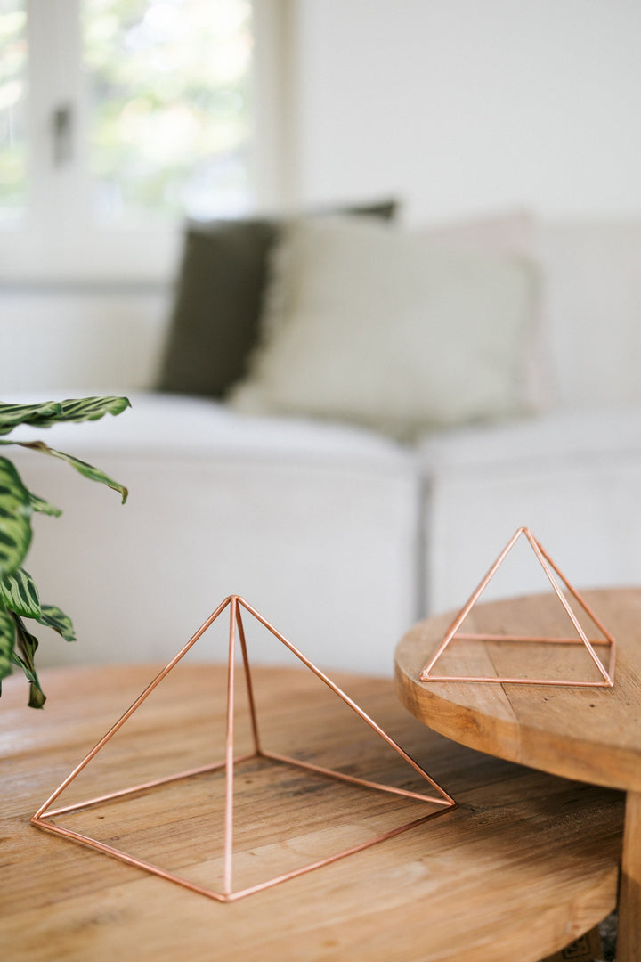 Kopero Kupfer-Pyramide Energizer Glatt, die kleine und die große Pyramide nebeneinander auf zwei Holztischen