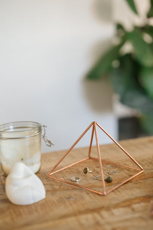 Kopero Kupfer-Pyramide Energizer Glatt Klein (14,56 cm), mit Schmuck darunter neben einem Kerzenglas und einer Figur