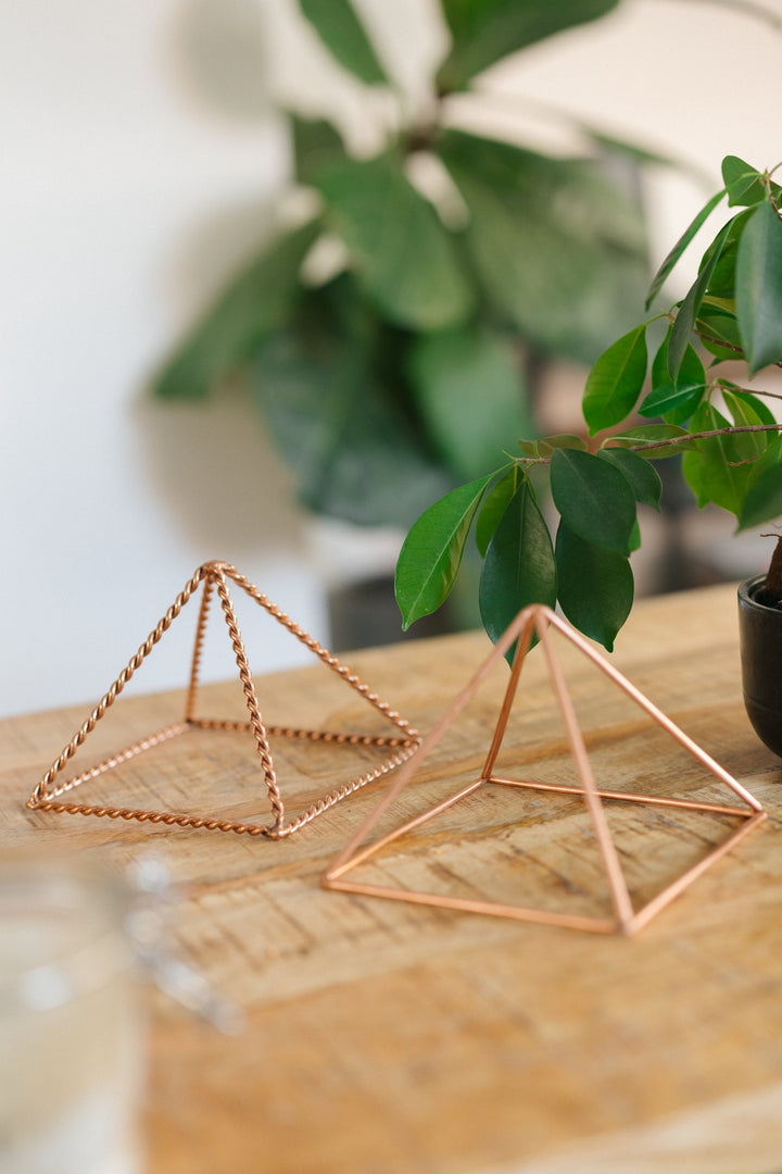 Die kleine glatte und die kleine gedrehte Pyramide nebeneinander auf einem Holztisch