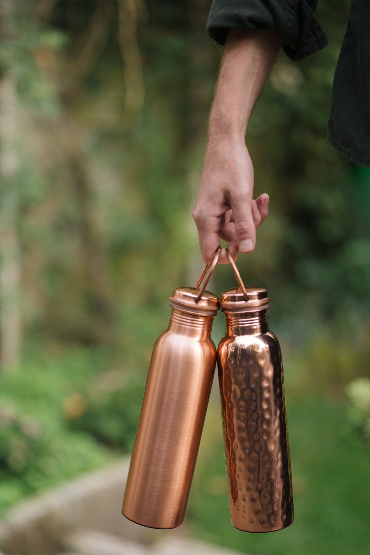 Kopero Kupferflasche, die glatte und die gehämmerte Flasche zusammen am Hebel in einer Hand