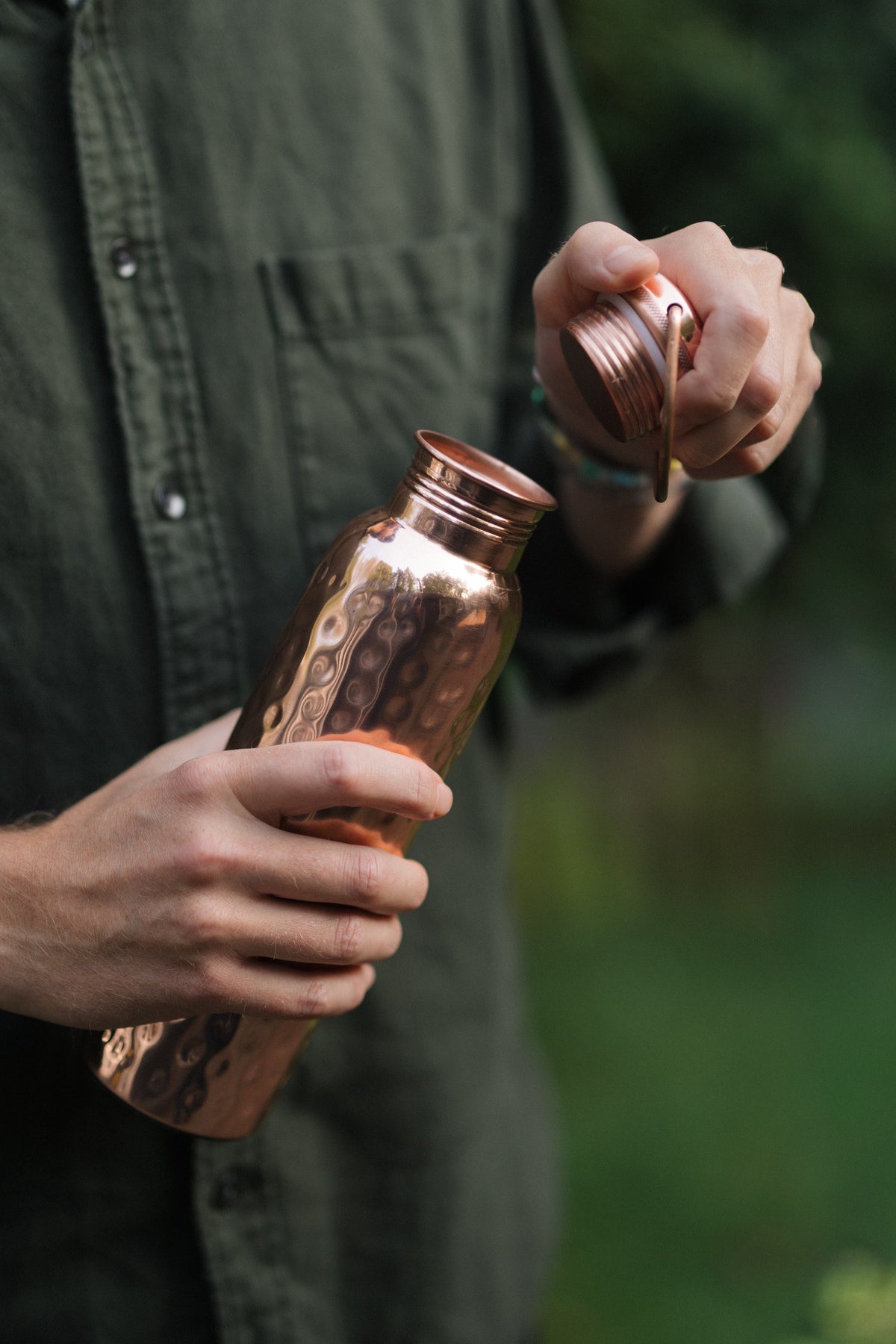 Kopero Kupferflasche Gehämmert, in einer Hand, während die Kappe abgeschraubt wird
