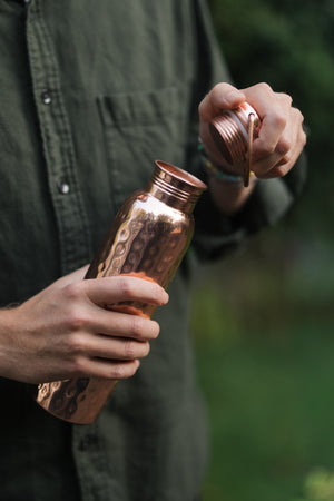Kopero Kupferflasche Gehämmert, in einer Hand, während die Kappe abgeschraubt wird