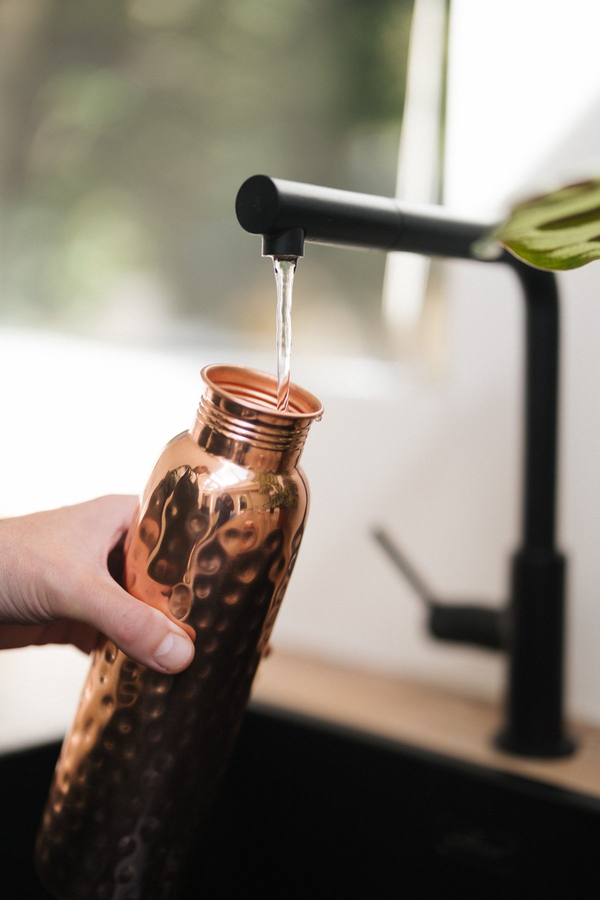 Kopero Kupferflasche Gehämmert, unter dem Wasserhahn, während Wasser hineinläuft
