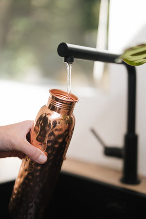 Kopero Kupferflasche Gehämmert, unter dem Wasserhahn, während Wasser hineinläuft