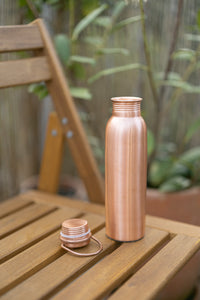 Kopero Kupfer-Wasserflasche Glatt mit abgenommenem Deckel auf einem Holzgartenstuhl