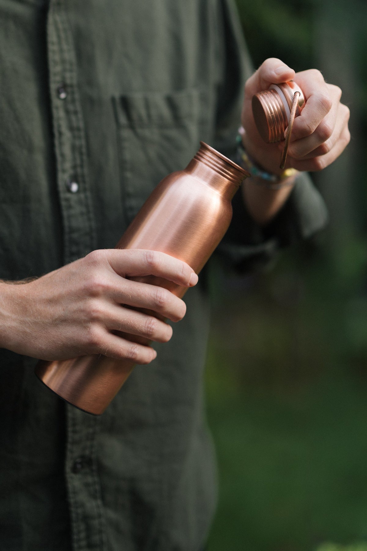 Kopero Kupferflasche Glatt, in einer Hand, während die Kappe abgeschraubt wird