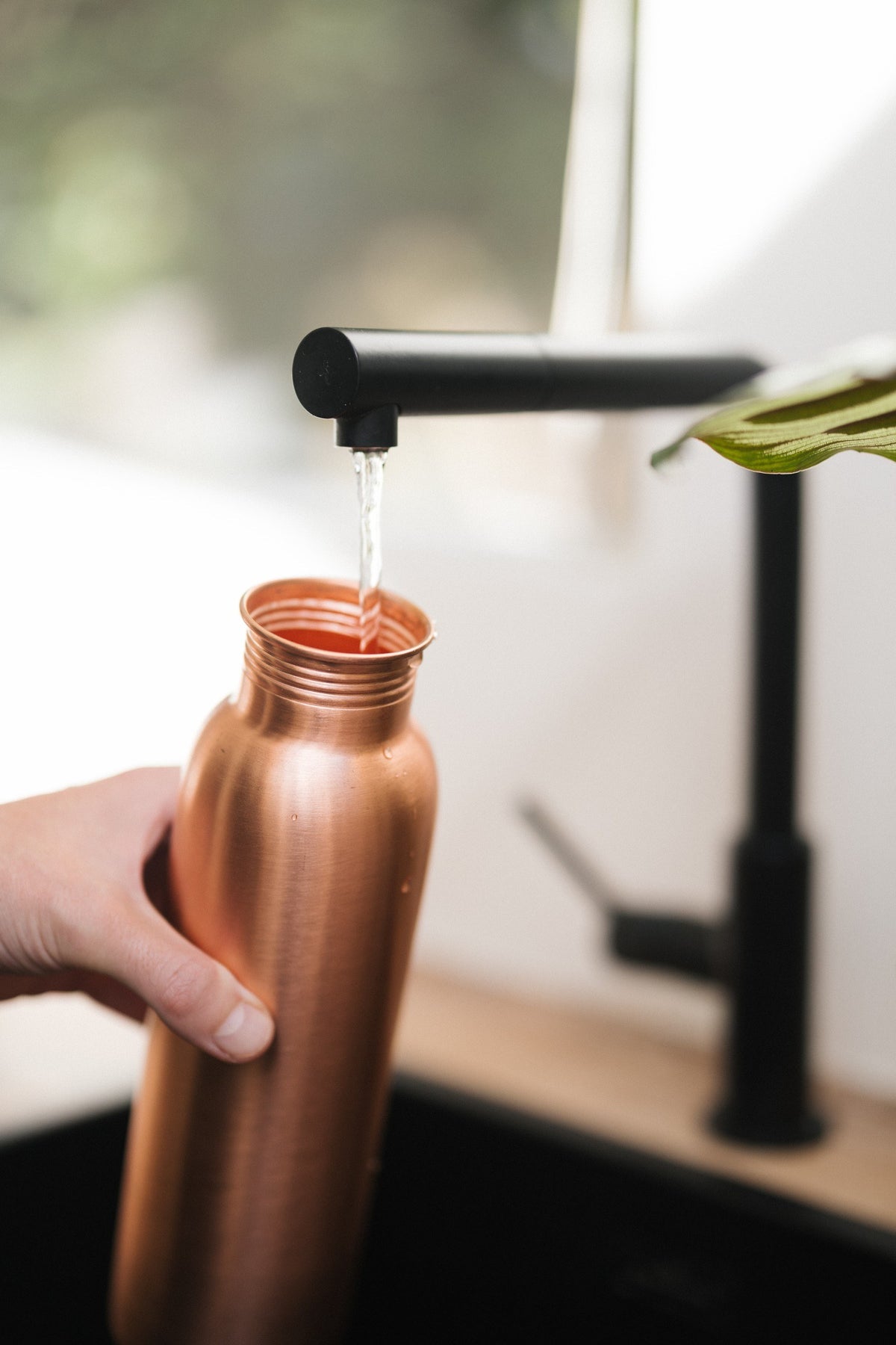 Kopero Kupferflasche Glatt, unter dem Wasserhahn, während Wasser hineinläuft